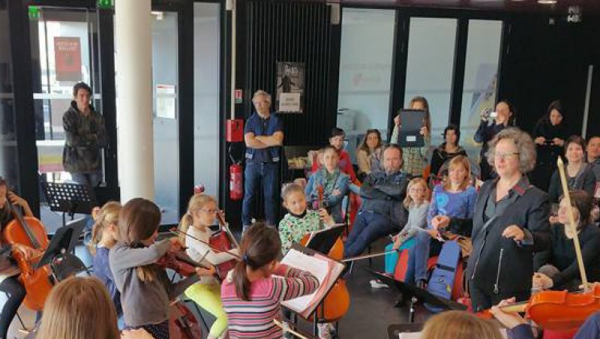 Enfants jouant des instruments devant un public de parents